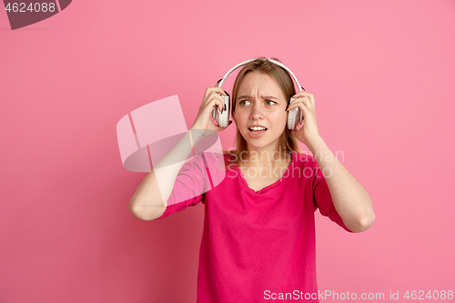 Image of Caucasian young woman\'s monochrome portrait on pink studio background, emotinal and beautiful