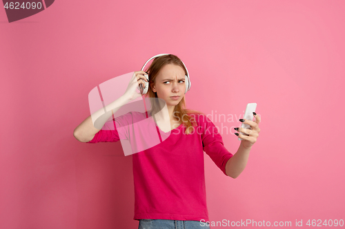 Image of Caucasian young woman\'s monochrome portrait on pink studio background, emotinal and beautiful