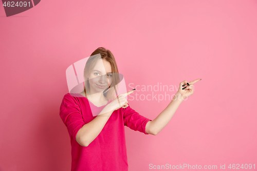 Image of Caucasian young woman\'s monochrome portrait on pink studio background, emotinal and beautiful