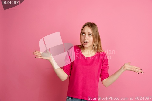 Image of Caucasian young woman\'s monochrome portrait on pink studio background, emotinal and beautiful