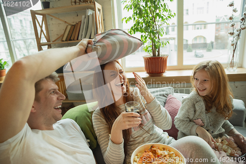 Image of Family spending nice time together at home, looks happy and cheerful, watching TV