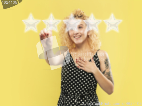 Image of Woman touching five star symbol to increase rating of company, app or service