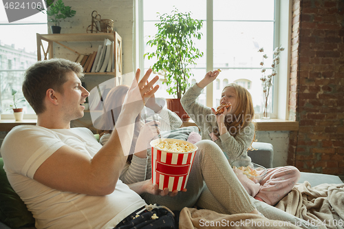 Image of Family spending nice time together at home, looks happy and cheerful, watching TV