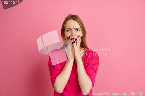 Image of Caucasian young woman\'s monochrome portrait on pink studio background, emotinal and beautiful