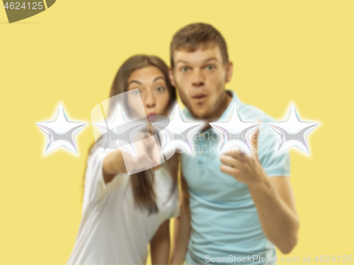 Image of Couple touching five star symbol to increase rating of company, app or service