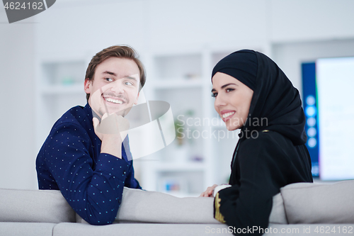 Image of young muslim couple watching TV together