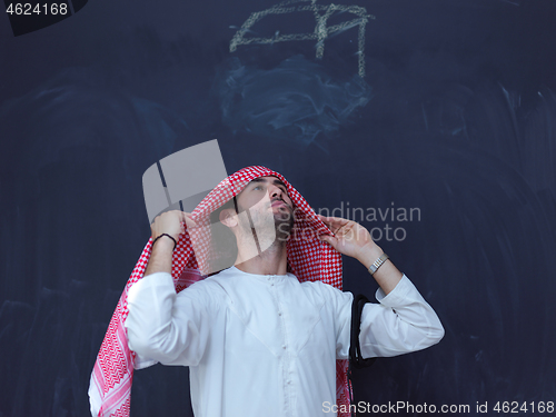 Image of portrait of arabian man in front of black chalkboard