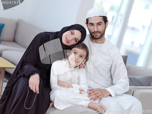 Image of muslim family reading Quran and praying at home