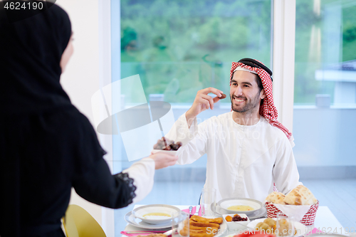 Image of Muslim family having Iftar dinner eating dates to break feast