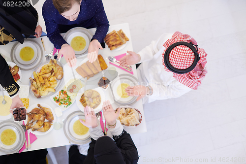 Image of traditional muslim family praying before iftar dinner top view