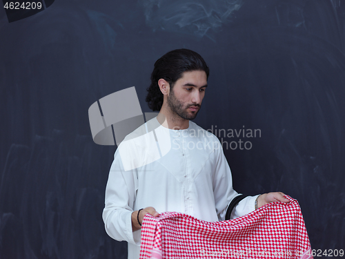 Image of portrait of arabian man in front of black chalkboard