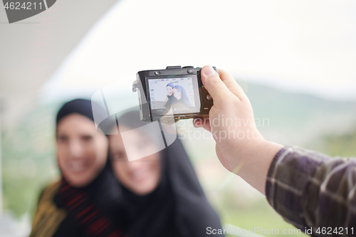 Image of a man takes a photo of muslim women with a camera