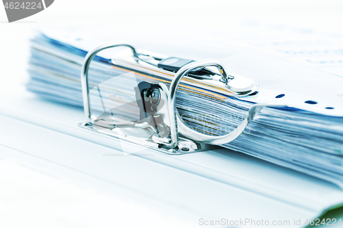 Image of Detail of open folder filled with documents in cyan  tone