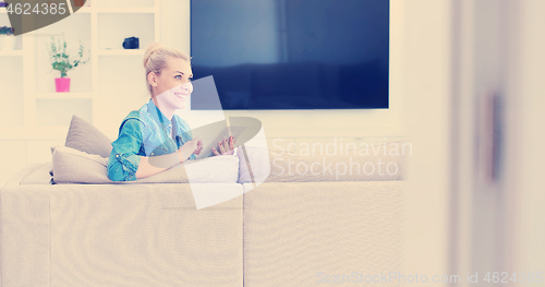 Image of woman on sofa using tablet computer