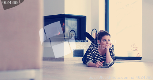 Image of young women using tablet computer on the floor