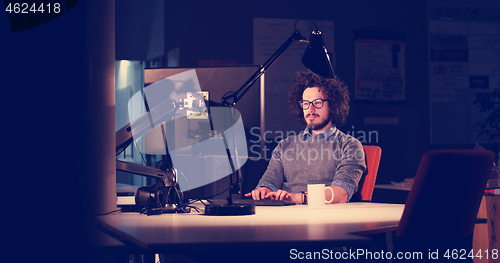 Image of man working on computer in dark office