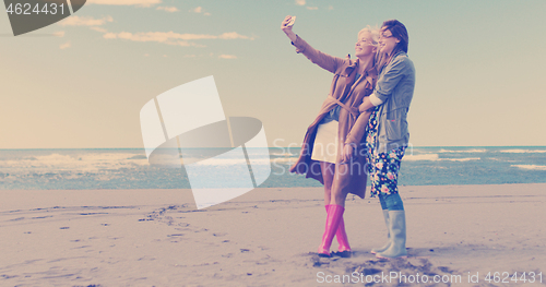 Image of Girls having time and taking selfie on a beach