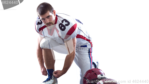 Image of American Football Player tie his shoe laces isolated on white