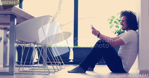 Image of young man using a tablet at home