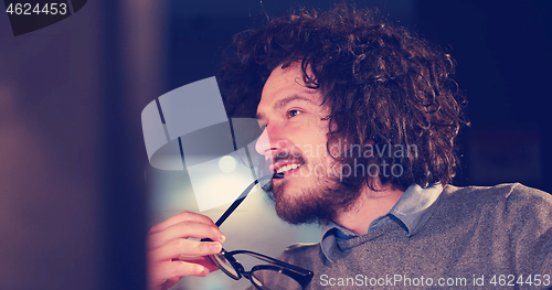 Image of man working on computer in dark office