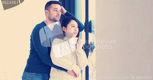 Image of multiethnic couple relaxing at modern home indoors