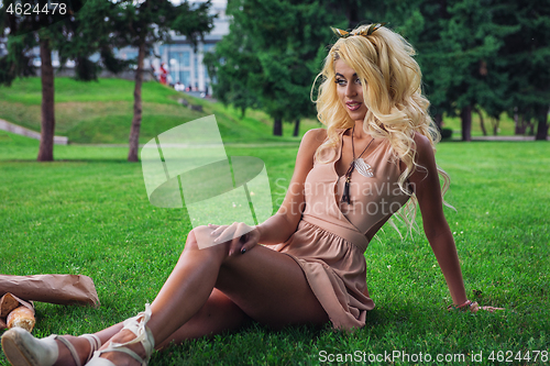 Image of eauty blonde alone young woman resting in the park