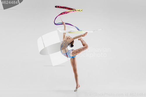 Image of The portrait of beautiful young brunette woman gymnast training calilisthenics exercise with ribbon