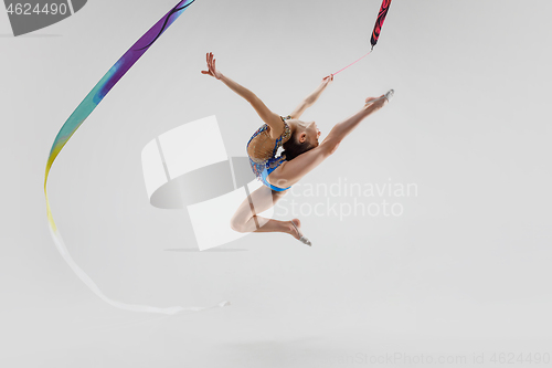 Image of The portrait of beautiful young brunette woman gymnast training calilisthenics exercise with ribbon