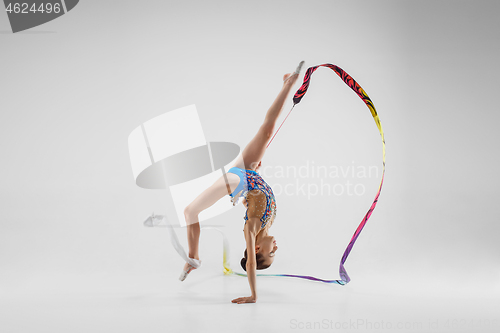 Image of The portrait of beautiful young brunette woman gymnast training calilisthenics exercise with ribbon