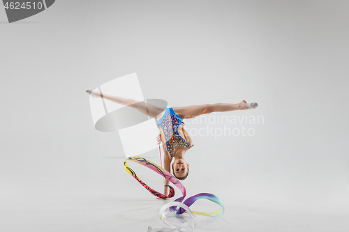 Image of The portrait of beautiful young brunette woman gymnast training calilisthenics exercise with ribbon