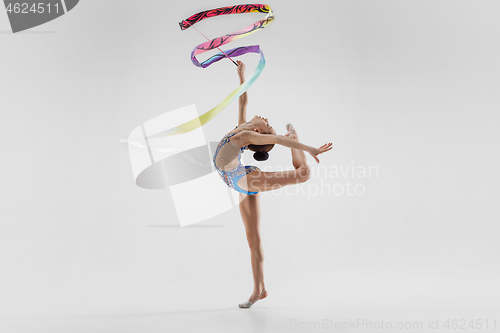 Image of The portrait of beautiful young brunette woman gymnast training calilisthenics exercise with ribbon