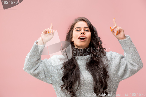 Image of The happy business woman standing and smiling against pastel background.