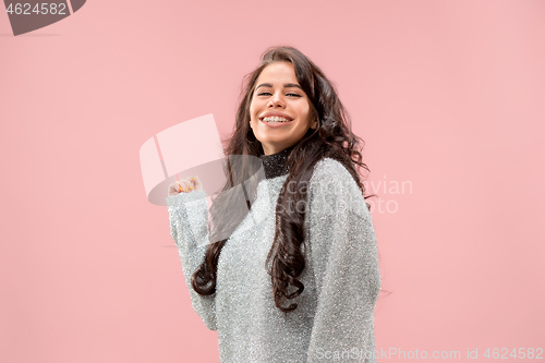 Image of The happy business woman standing and smiling against pastel background.