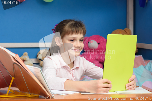 Image of The girl has done homework and communicates with friends via video calling.