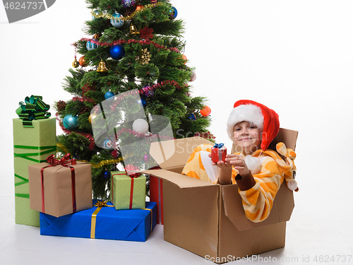 Image of The girl climbed up and sat in a box decorating a Christmas tree