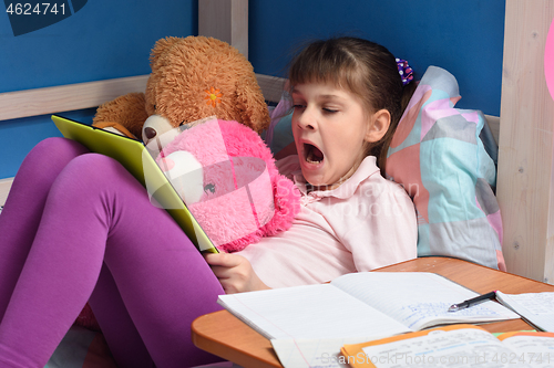 Image of Girl watching a boring video lesson while studying remotely at home