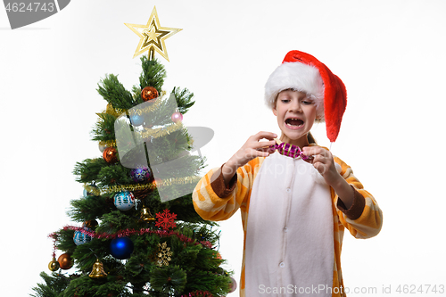 Image of Girl has fun holding a candy-shaped Christmas toy