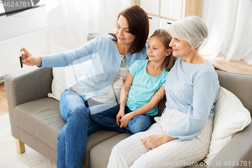 Image of mother, daughter and grandmother taking selfie