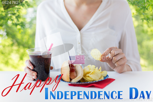 Image of close up of woman eating chips, hot dog and cola