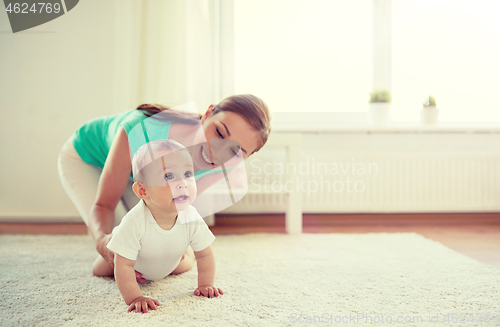 Image of happy mother playing with baby at home