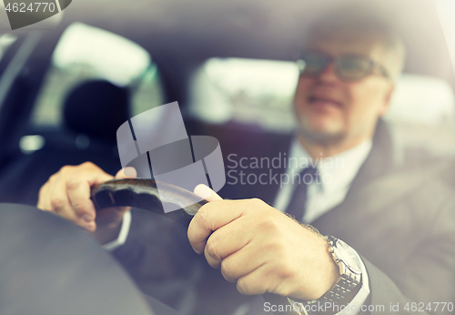 Image of senior businessman hands driving car