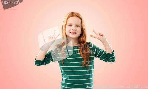 Image of smiling red haired girl showing peace gesture