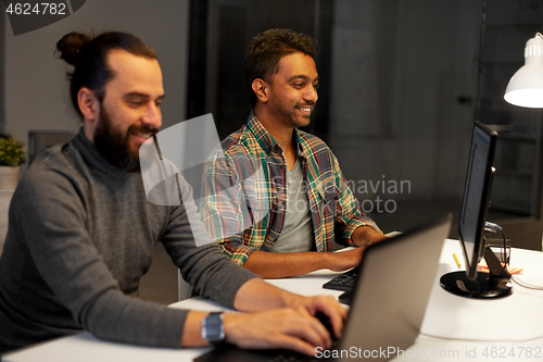 Image of creative team with computer working late at office