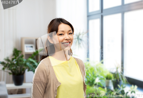 Image of happy asian woman over home background