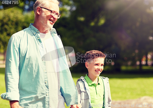 Image of grandfather and grandson walking at summer park