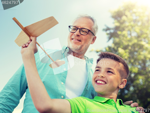 Image of senior man and boy with toy airplane over sky