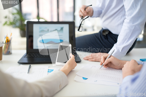 Image of business team with smartphone working at office