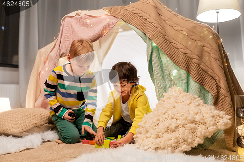 Image of boys playing toy blocks in kids tent at home