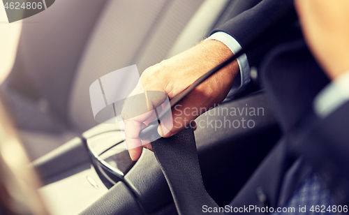 Image of senior businessman fastening car seat belt