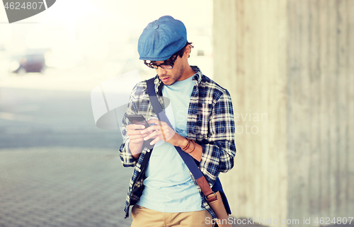 Image of hipster man texting message on smartphone